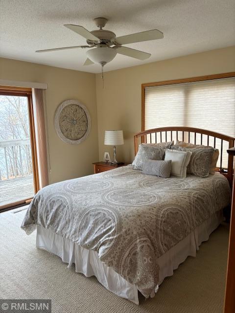 8012 Par Five Dr, South Harbor Twp, MN 56359 - bedroom with access to exterior, carpet, ceiling fan, and a textured ceiling