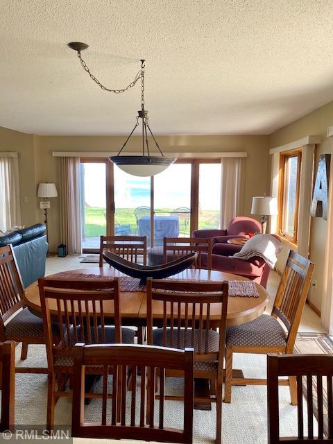 8012 Par Five Dr, South Harbor Twp, MN 56359 - carpeted dining space with plenty of natural light and a textured ceiling