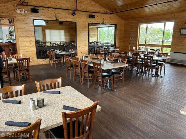 8012 Par Five Dr, South Harbor Twp, MN 56359 - dining room featuring wood walls, wooden ceiling, wood finished floors, and high vaulted ceiling