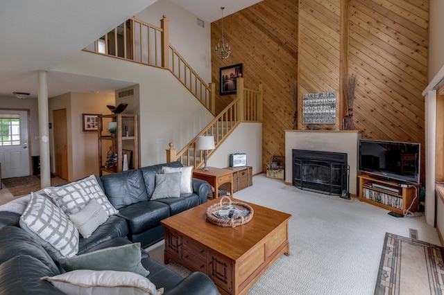 8012 Par Five Dr, South Harbor Twp, MN 56359 - living area with a towering ceiling, wood walls, stairway, carpet, and a fireplace with flush hearth