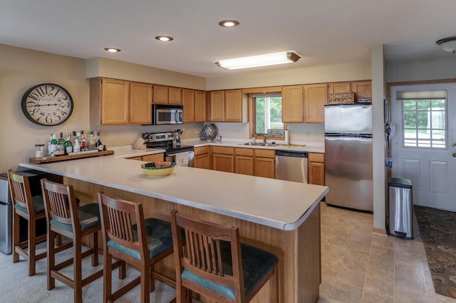 8012 Par Five Dr, South Harbor Twp, MN 56359 - kitchen featuring appliances with stainless steel finishes, light countertops, a peninsula, recessed lighting, and a breakfast bar area