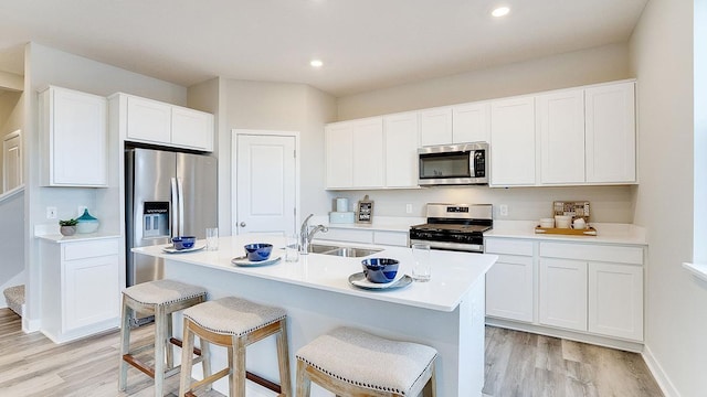 6562 208th St W, Farmington, MN 55024 - kitchen with stainless steel appliances, light wood finished floors, a sink, a breakfast bar area, and recessed lighting