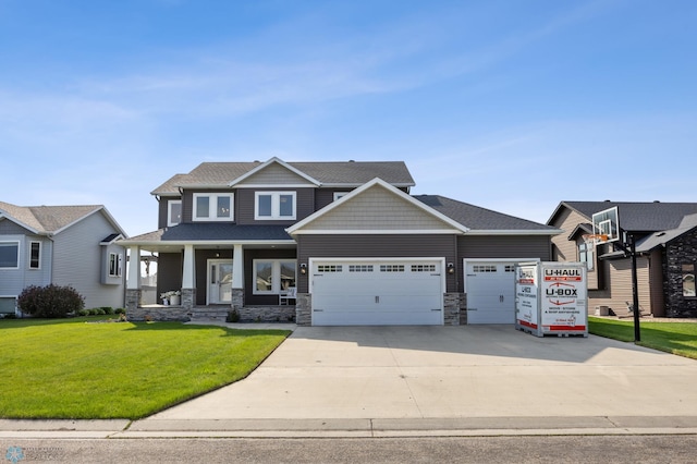 508 13th St NE, Dilworth, MN 56529 - craftsman house with a garage, a front yard, a porch, stone siding, and driveway
