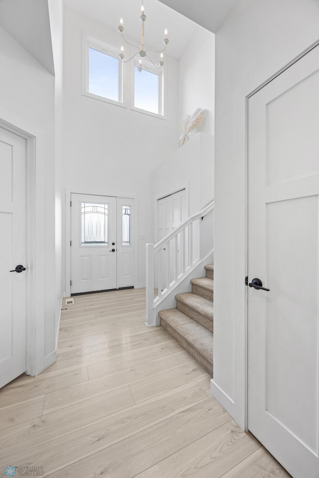 508 13th St NE, Dilworth, MN 56529 - foyer entrance with a chandelier, a high ceiling, light wood-style floors, stairs, and baseboards