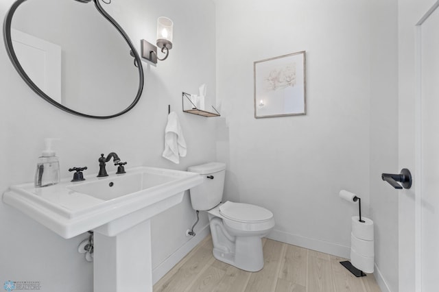 508 13th St NE, Dilworth, MN 56529 - half bath featuring wood finished floors, baseboards, and toilet
