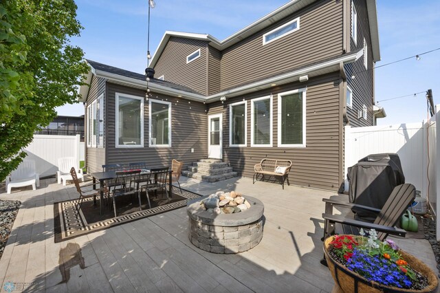 508 13th St NE, Dilworth, MN 56529 - back of property with a fire pit, a wooden deck, and outdoor dining area