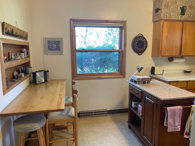 37165 300th Ave NE, Rollis Twp, MN 56724 - kitchen with light countertops, open shelves, brown cabinetry, and baseboards
