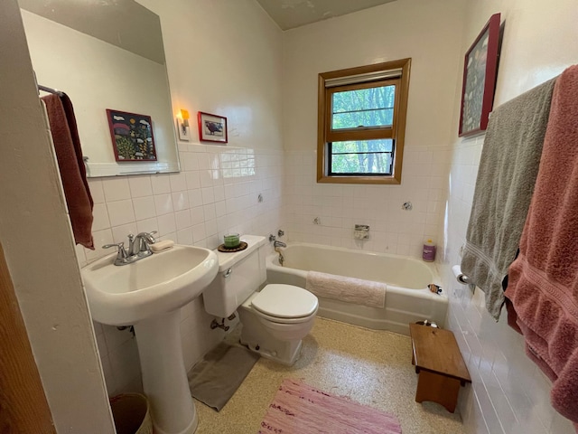 37165 300th Ave NE, Rollis Twp, MN 56724 - full bathroom with tile walls, a tub to relax in, toilet, and a wainscoted wall