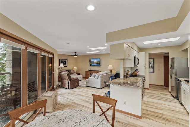 14575 Burma Ave W Unit 306, Rosemount, MN 55068 - kitchen featuring appliances with stainless steel finishes, a skylight, light stone counters, white cabinetry, and recessed lighting