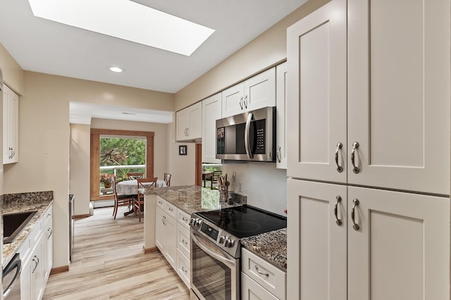 14575 Burma Ave W Unit 306, Rosemount, MN 55068 - kitchen with stainless steel appliances, a skylight, white cabinetry, light wood finished floors, and recessed lighting