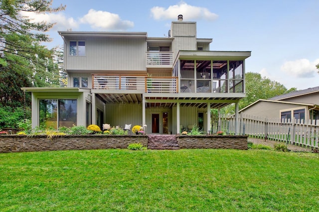 back of house featuring a sunroom, a chimney, and a balcony