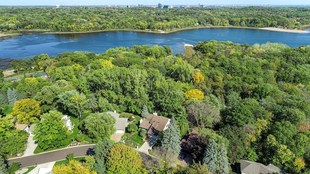 aerial view of property's location featuring a forest and a nearby body of water