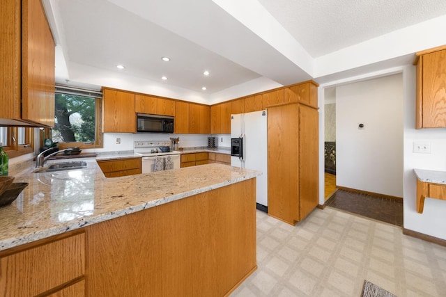 kitchen with white appliances, a sink, a raised ceiling, light floors, and recessed lighting
