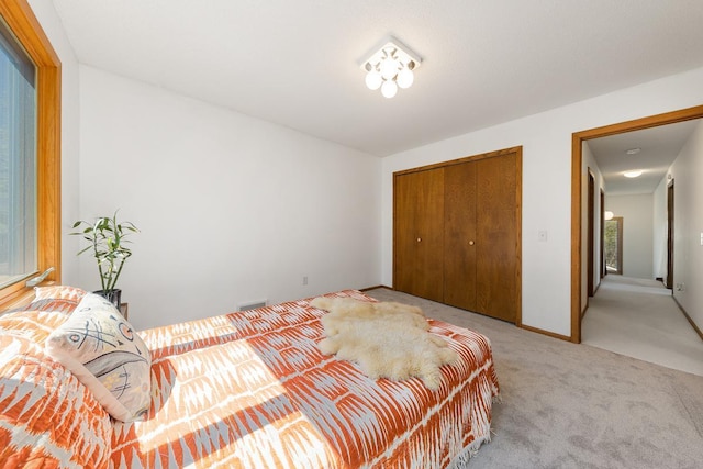 bedroom featuring light carpet and a closet