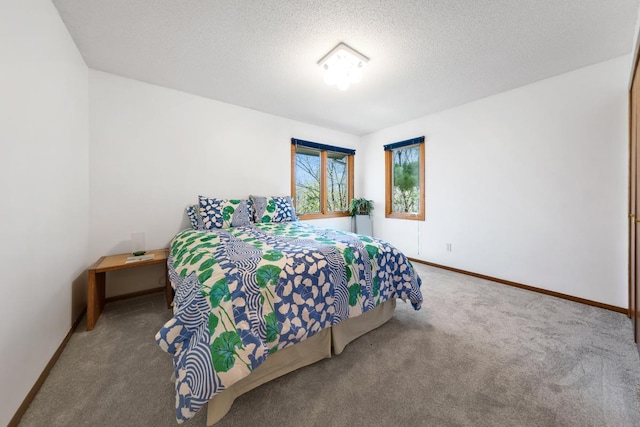 bedroom with carpet, baseboards, and a textured ceiling