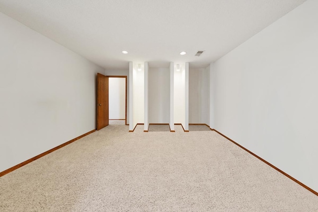 empty room featuring baseboards, recessed lighting, and light colored carpet