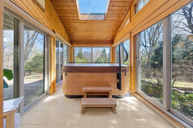 sunroom / solarium with vaulted ceiling, a jacuzzi, plenty of natural light, tile patterned floors, and a skylight
