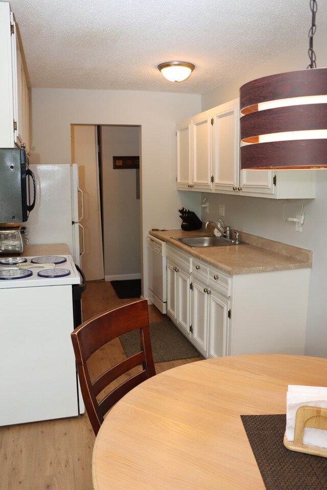 814 Old Settlers Trl Unit 6, Hopkins, MN 55343 - kitchen featuring white appliances, a sink, light countertops, white cabinets, and wood finished floors