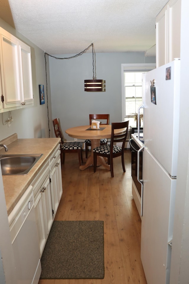 814 Old Settlers Trl Unit 6, Hopkins, MN 55343 - kitchen featuring white appliances, a sink, light wood finished floors, and white cabinets
