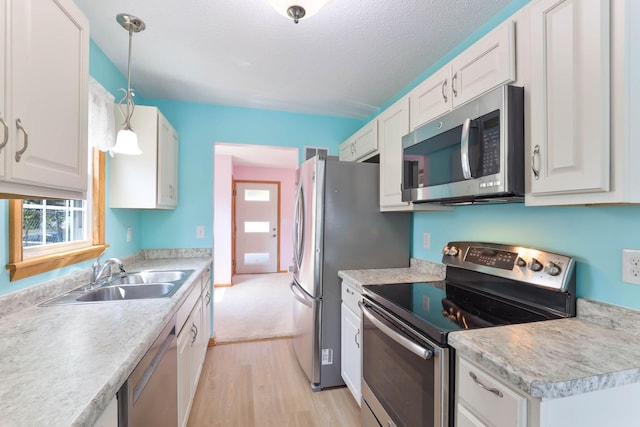 864 Howard St N, Saint Paul, MN 55119 - kitchen with appliances with stainless steel finishes, a sink, light wood-style flooring, and white cabinets