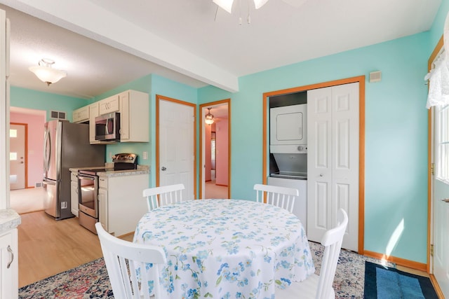 864 Howard St N, Saint Paul, MN 55119 - dining room featuring stacked washer and clothes dryer, a ceiling fan, light wood-style floors, and baseboards