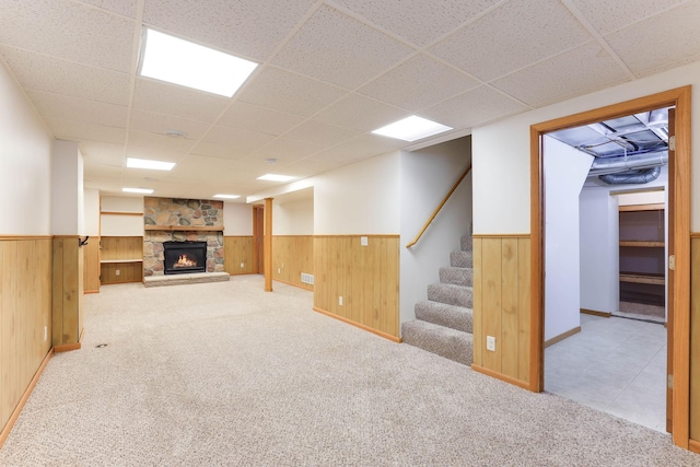 864 Howard St N, Saint Paul, MN 55119 - finished below grade area featuring a wainscoted wall, a drop ceiling, carpet flooring, a stone fireplace, and wood walls