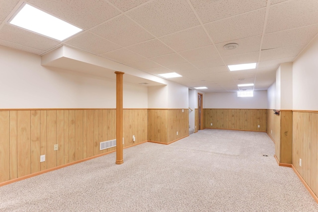 864 Howard St N, Saint Paul, MN 55119 - below grade area featuring wainscoting, a drop ceiling, light colored carpet, wooden walls, and baseboards