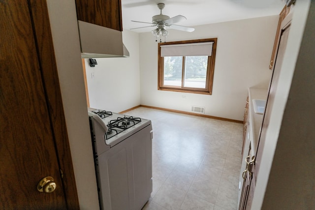1651 5th St E, Saint Paul, MN 55106 - kitchen with white gas stove, a ceiling fan, and baseboards