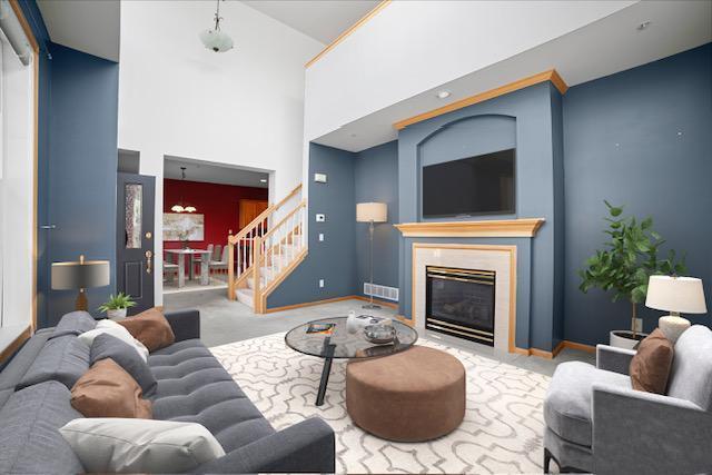 11353 Fergus St NE Unit A, Blaine, MN 55449 - carpeted living room featuring stairway, high vaulted ceiling, a high end fireplace, and baseboards
