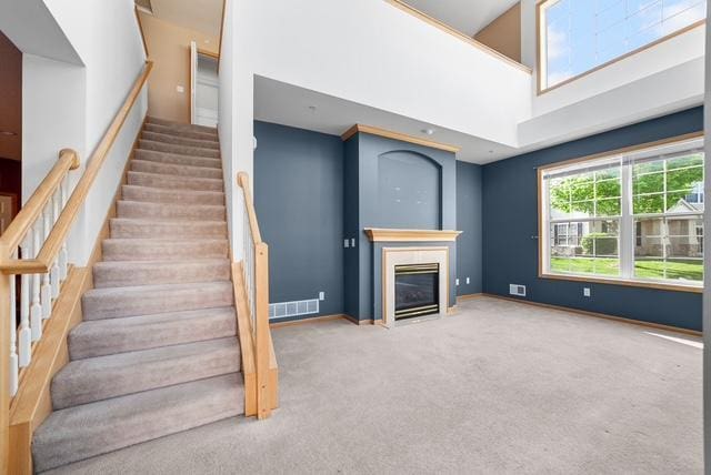 11353 Fergus St NE Unit A, Blaine, MN 55449 - stairway with carpet floors, a glass covered fireplace, a towering ceiling, and baseboards