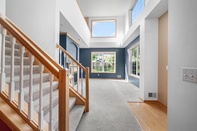 11353 Fergus St NE Unit A, Blaine, MN 55449 - foyer entrance featuring a high ceiling, stairs, baseboards, and carpet