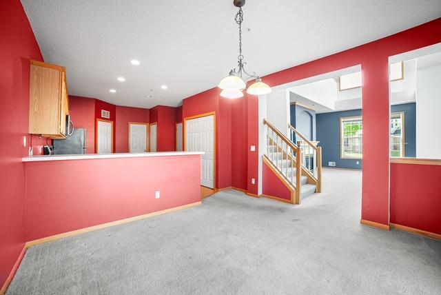 11353 Fergus St NE Unit A, Blaine, MN 55449 - unfurnished dining area with stairs, carpet floors, recessed lighting, and baseboards