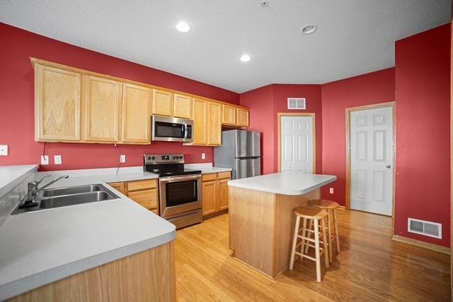 11353 Fergus St NE Unit A, Blaine, MN 55449 - kitchen featuring stainless steel appliances, a sink, light wood-type flooring, light brown cabinetry, and recessed lighting