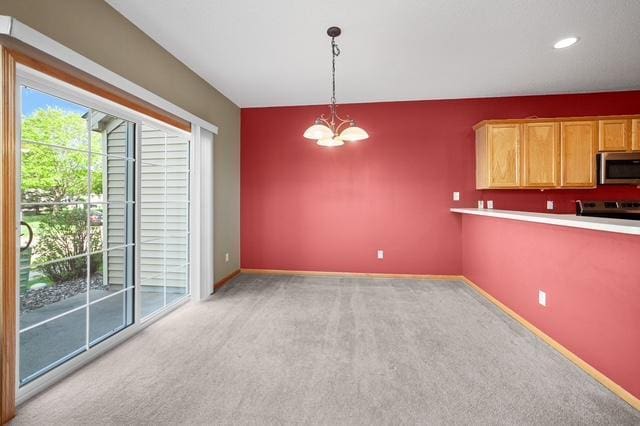 11353 Fergus St NE Unit A, Blaine, MN 55449 - kitchen featuring stainless steel microwave, light colored carpet, pendant lighting, baseboards, and a chandelier