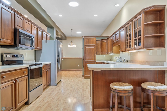 1395 Highpointe Dr N, Fargo, ND 58102 - kitchen featuring stainless steel appliances, a peninsula, light countertops, light wood-style flooring, and recessed lighting