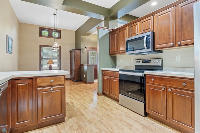 1395 Highpointe Dr N, Fargo, ND 58102 - kitchen with stainless steel appliances, light countertops, brown cabinets, light wood-type flooring, and hanging light fixtures