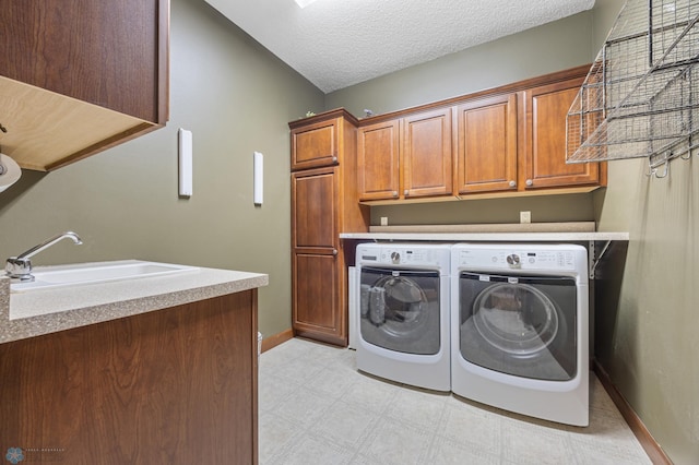 1395 Highpointe Dr N, Fargo, ND 58102 - laundry area featuring washer and dryer, cabinet space, light flooring, baseboards, and a textured ceiling