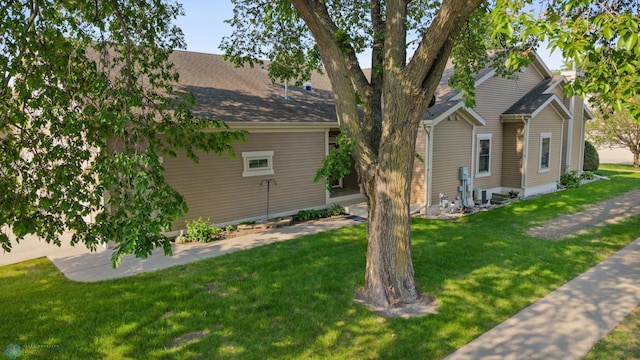 1395 Highpointe Dr N, Fargo, ND 58102 - view of home's exterior with a yard, roof with shingles, and central AC unit