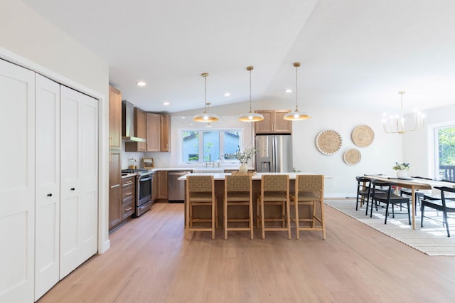 8464 Greenwood Dr, Mounds View, MN 55112 - kitchen with stainless steel appliances, light wood-style flooring, wall chimney range hood, light countertops, and a sink