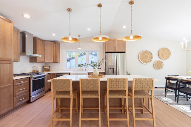 8464 Greenwood Dr, Mounds View, MN 55112 - kitchen with appliances with stainless steel finishes, wall chimney exhaust hood, light wood-type flooring, a kitchen bar, and recessed lighting