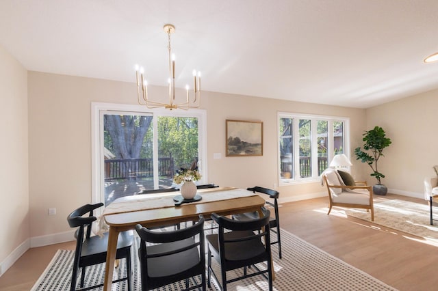8464 Greenwood Dr, Mounds View, MN 55112 - dining space featuring a chandelier, light wood-style flooring, and baseboards