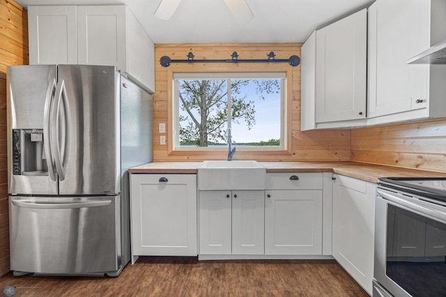 24527 Twilight Ln, Lida Twp, MN 56572 - kitchen featuring appliances with stainless steel finishes, wall chimney range hood, butcher block counters, dark wood-style floors, and white cabinetry