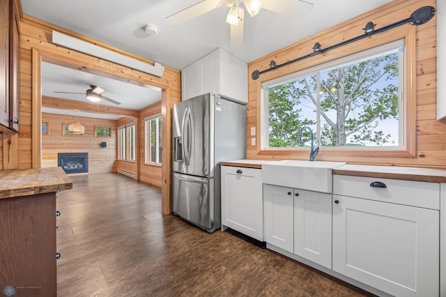 24527 Twilight Ln, Lida Twp, MN 56572 - kitchen featuring stainless steel fridge, ceiling fan, wooden walls, a sink, and butcher block counters