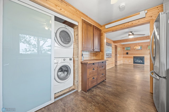 24527 Twilight Ln, Lida Twp, MN 56572 - laundry room featuring wooden walls, stacked washer / drying machine, ceiling fan, and dark wood-style floors