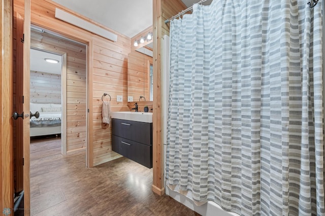 24527 Twilight Ln, Lida Twp, MN 56572 - ensuite bathroom featuring wooden walls, vanity, and curtained shower