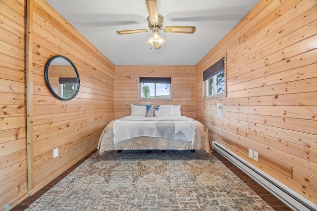 24527 Twilight Ln, Lida Twp, MN 56572 - bedroom with baseboard heating, wooden walls, wood finished floors, and a ceiling fan