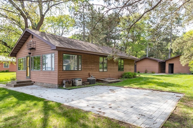 6769 County Road 13, Lake Edward Twp, MN 56468 - back of property featuring a patio area, a lawn, and a shingled roof