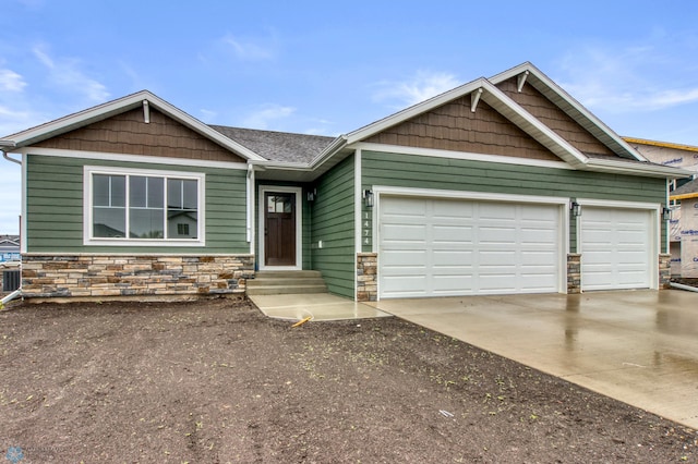 1474 66th Ave S, Fargo, ND 58104 - craftsman-style home featuring stone siding, concrete driveway, an attached garage, and entry steps