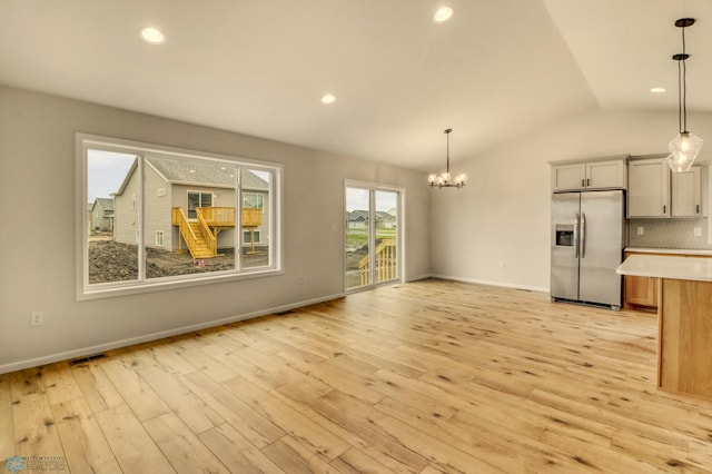 1474 66th Ave S, Fargo, ND 58104 - unfurnished living room featuring a chandelier, vaulted ceiling, light wood-type flooring, baseboards, and recessed lighting