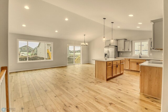 1474 66th Ave S, Fargo, ND 58104 - kitchen featuring stainless steel fridge with ice dispenser, a sink, a chandelier, open floor plan, and lofted ceiling